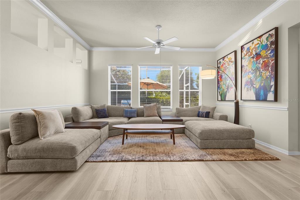 A living room features a large sectional sofa, a wooden coffee table, and two wall paintings — 4510 50TH DRIVE W, BRADENTON, FL