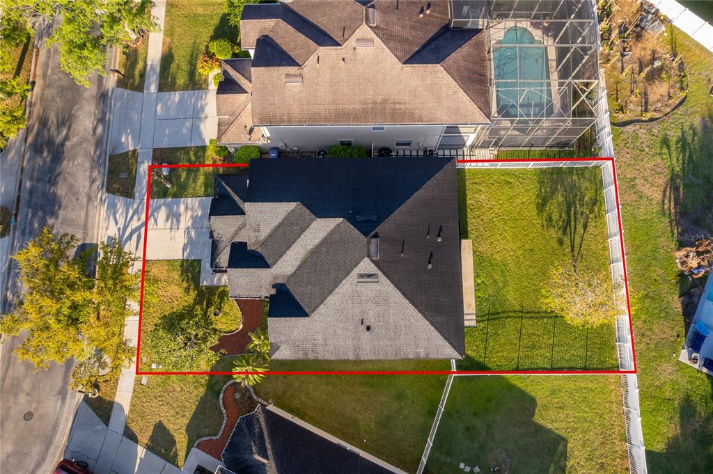 An aerial view shows a house with a dark roof and a fenced backyard — 2591 DOVER GLEN CIRCLE, ORLANDO, FL