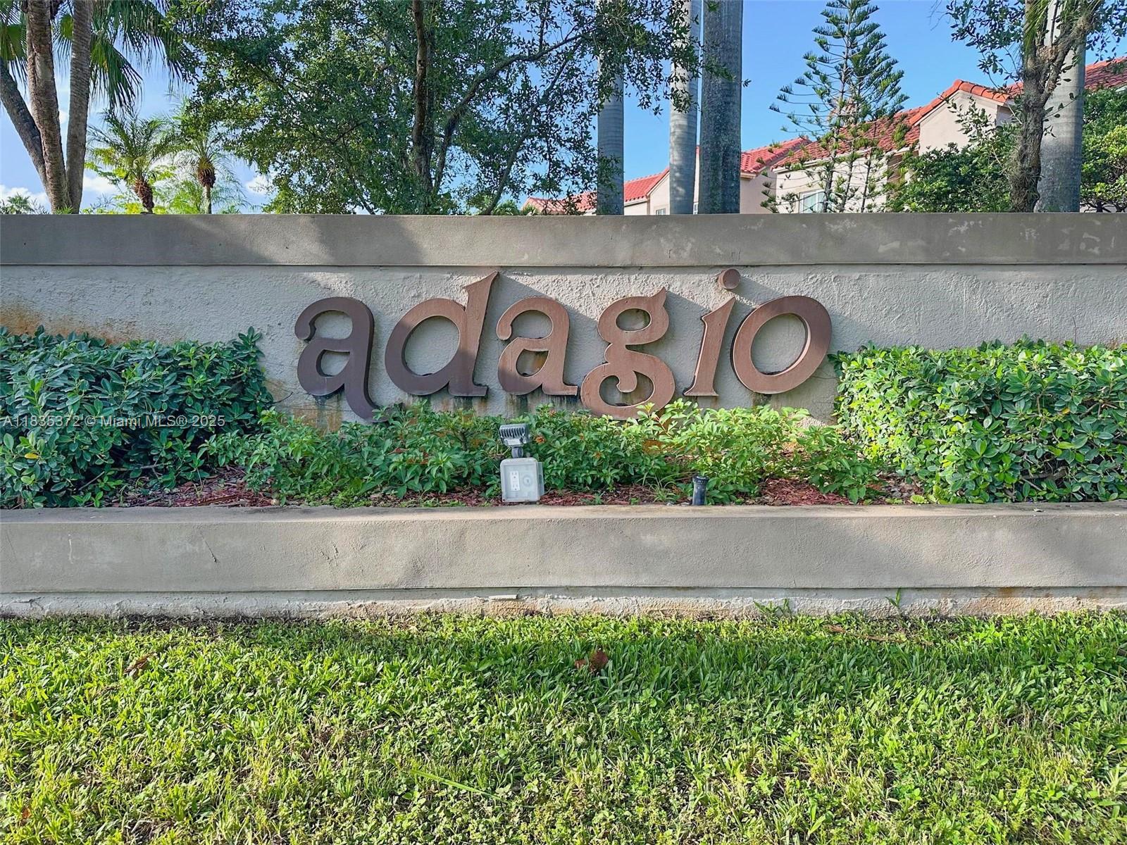 A concrete sign with the word adagio stands in front of green bushes and trees — 11532 SW 148th Path, Miami FL 33196, MIAMI, FL