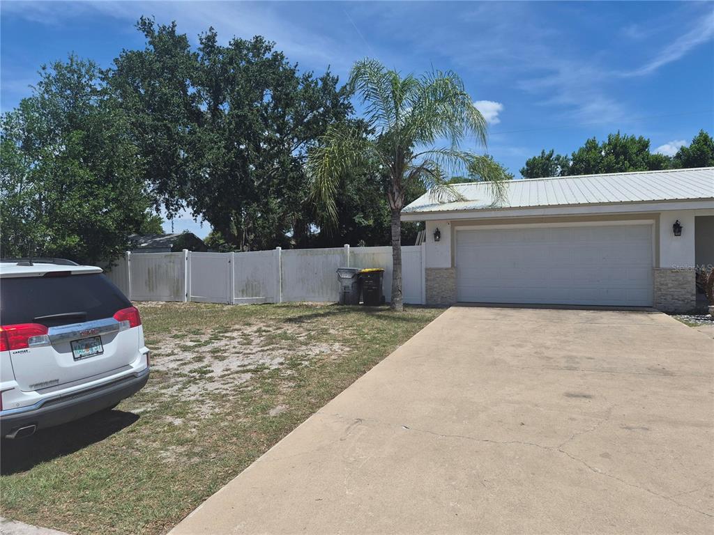 A white vinyl fence borders the side of a house with a concrete driveway — 2018 MARILYN AVENUE, WINTER HAVEN, FL