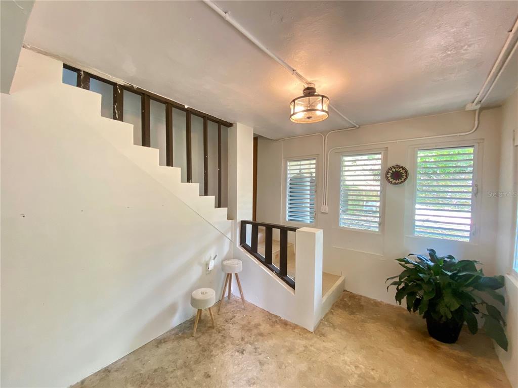 A room with a staircase, louvered windows, a pendant light, and a concrete floor — 4.8 CARR. 784 KM ROAD, CAGUAS, PR