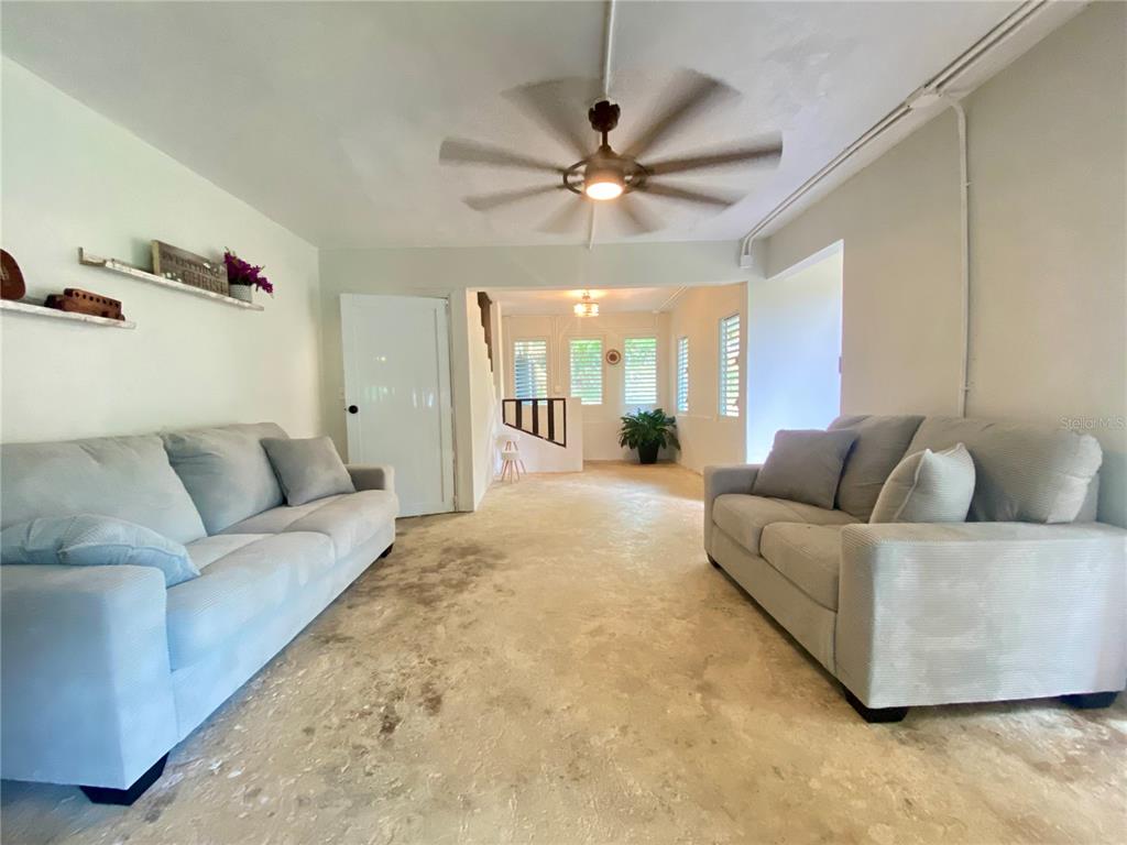 A living room features two light gray sofas, a ceiling fan, and unfinished concrete flooring — 4.8 CARR. 784 KM ROAD, CAGUAS, PR