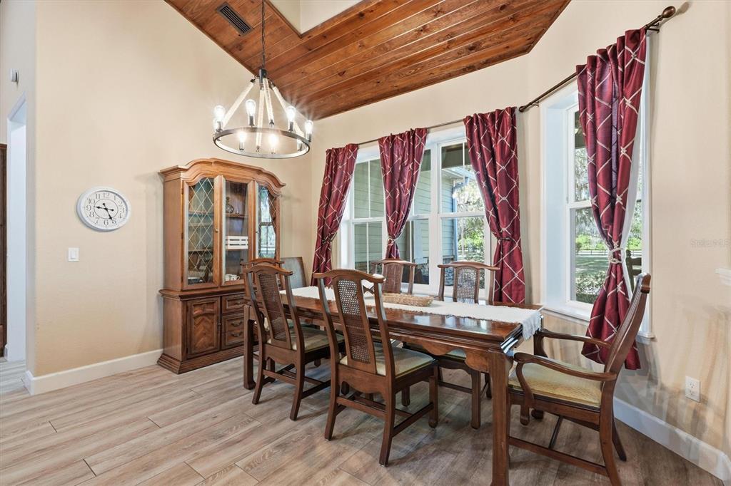 A dining room features a wooden vaulted ceiling, a chandelier, a hutch, and a table — 12501 N US HIGHWAY 27, OCALA, FL