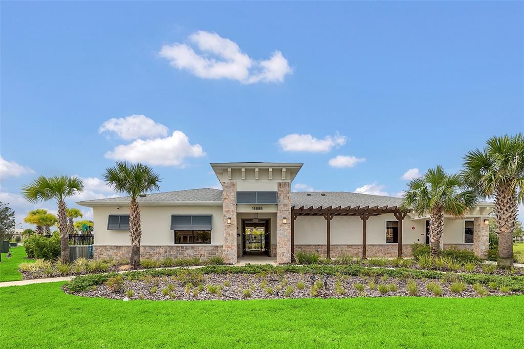 A single-story community building with a stone facade, a central entrance, and surrounding palm trees — 14186 TITLE WAY, WINTER GARDEN, FL