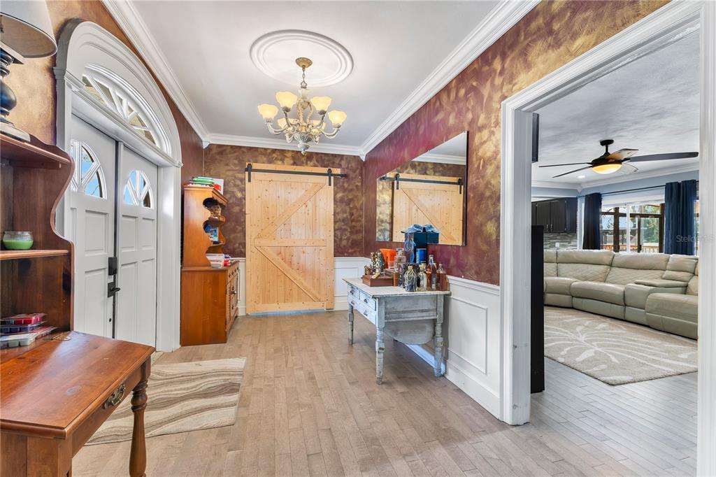 A spacious metal-walled garage features a concrete floor, ceiling fans, and a large tool chest — 811 FAIRLINGTON DRIVE, LAKELAND, FL