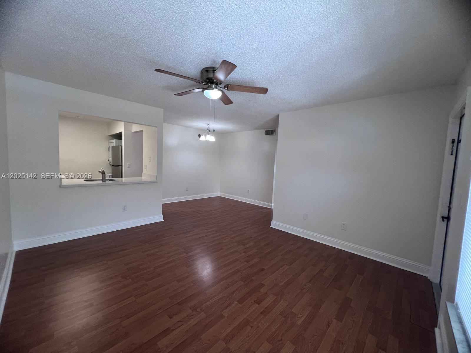 An empty living room features wood-look flooring, white walls, and a ceiling fan — 2570 W 67th Pl # 2, Hialeah FL 33016, HIALEAH, FL