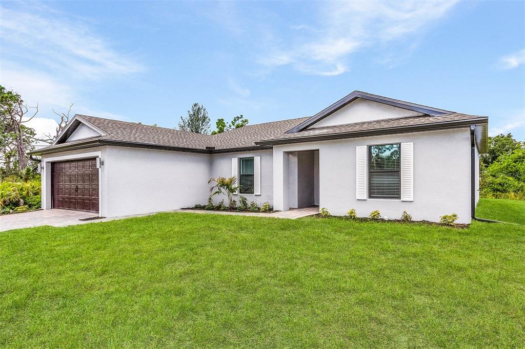 A single-story house with a light gray exterior, dark roof, and an attached garage — 6007 GILLOT BOULEVARD, PORT CHARLOTTE, FL