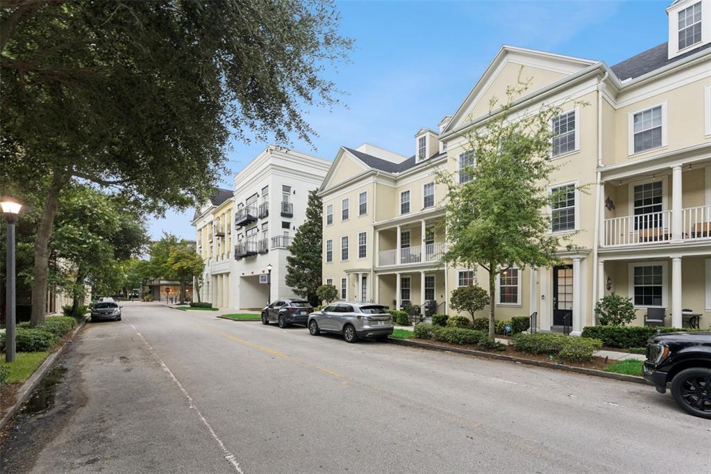 A street view of multi-story townhouses with balconies and parked cars on a paved road — 1650 PROSPECT AVENUE, ORLANDO, FL