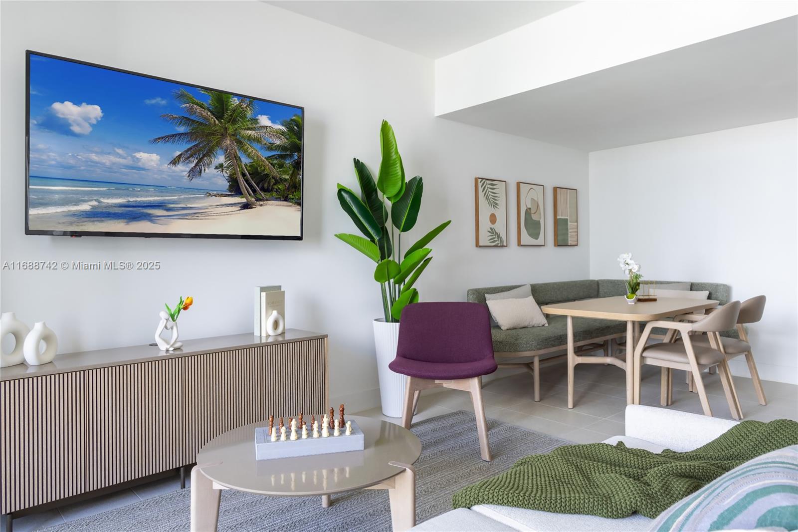 A living and dining area features a wall-mounted television, a purple chair, and green seating — 159 NE 6TH ST # 3013, Miami FL 33132, MIAMI, FL