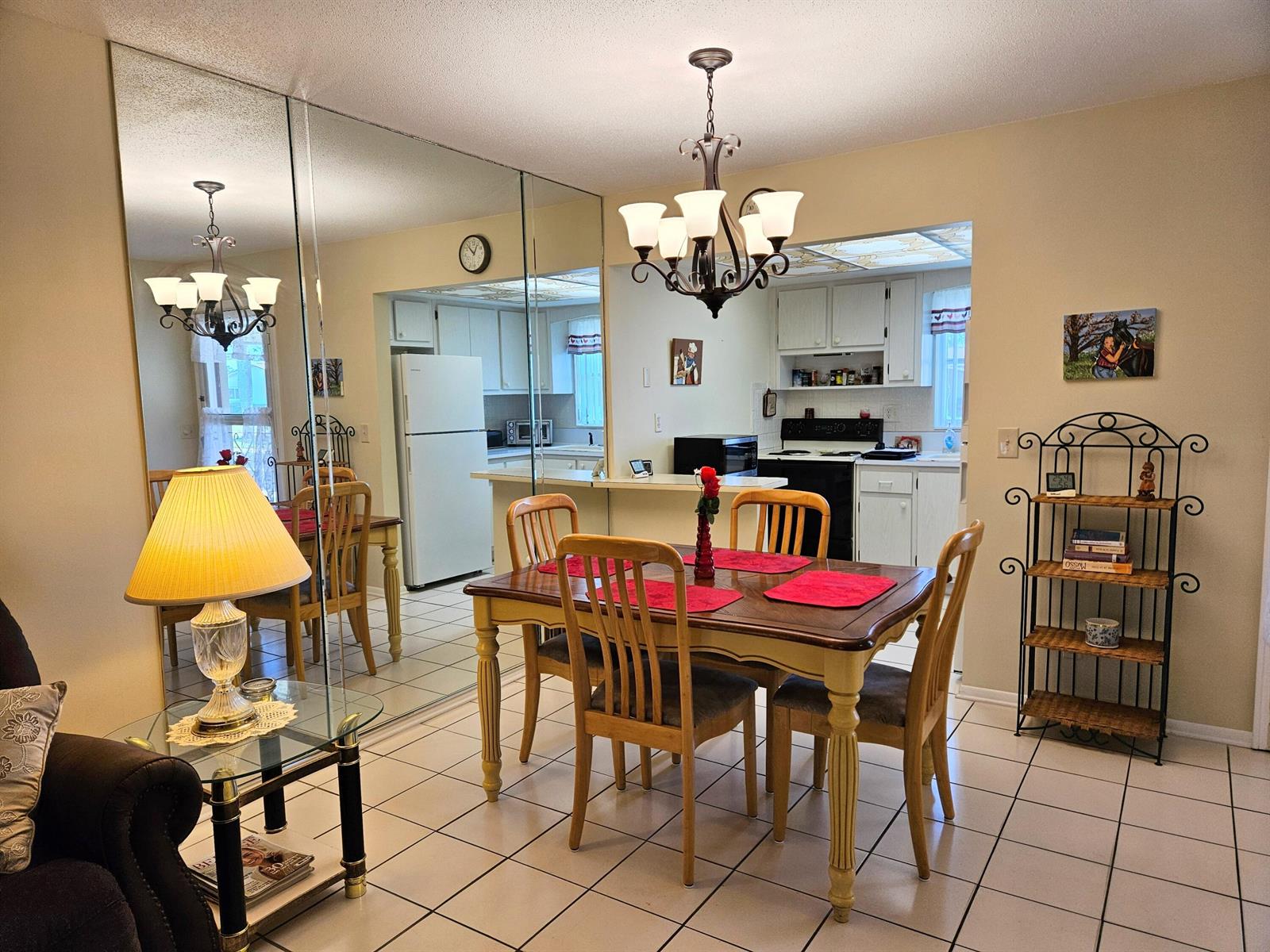 A dining area with a wooden table, chairs, and a large mirrored wall — 2950 Crosley Drive E # C, West Palm Beach FL 33415, WEST PALM BEACH, FL