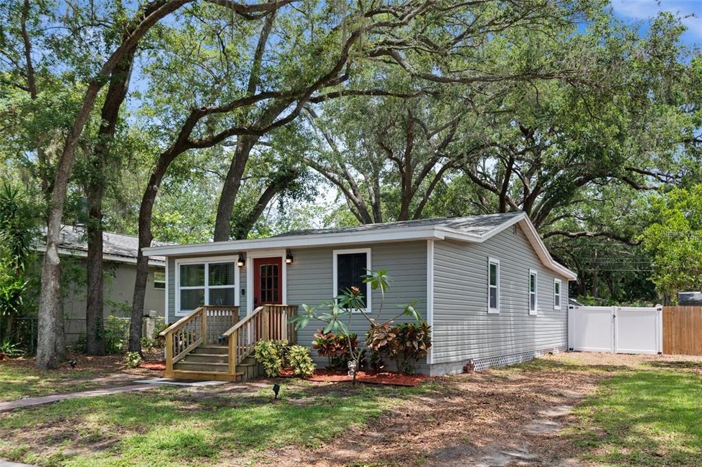 A single-story gray house with a red front door and a wooden porch — 508 5TH AVENUE NE, LARGO, FL