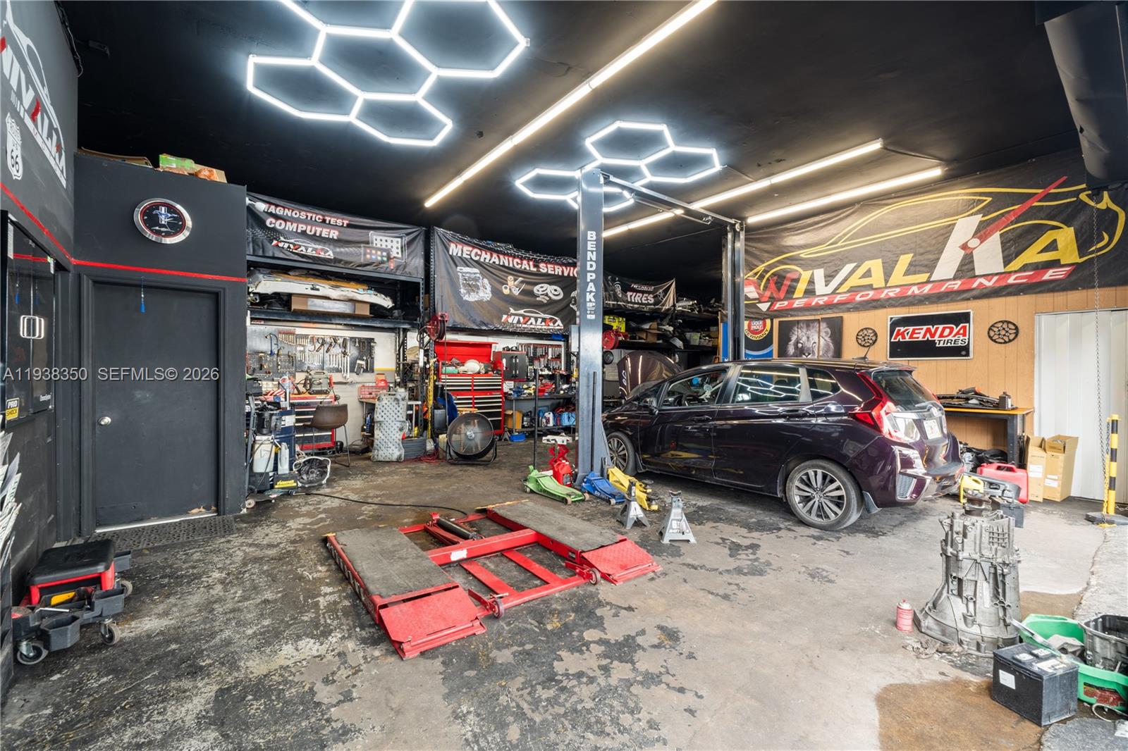 An auto repair shop features a car lift, tools, equipment, and a vehicle inside — 4350 NW 32nd Ave, Miami FL 33142, MIAMI, FL