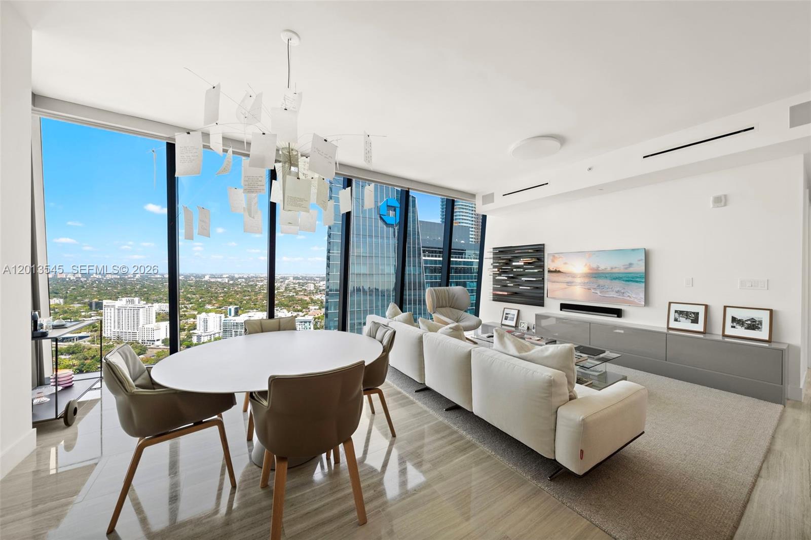 A modern living and dining area features floor-to-ceiling windows with expansive city views — 1451 Brickell Ave # 4103, Miami FL 33131, MIAMI, FL
