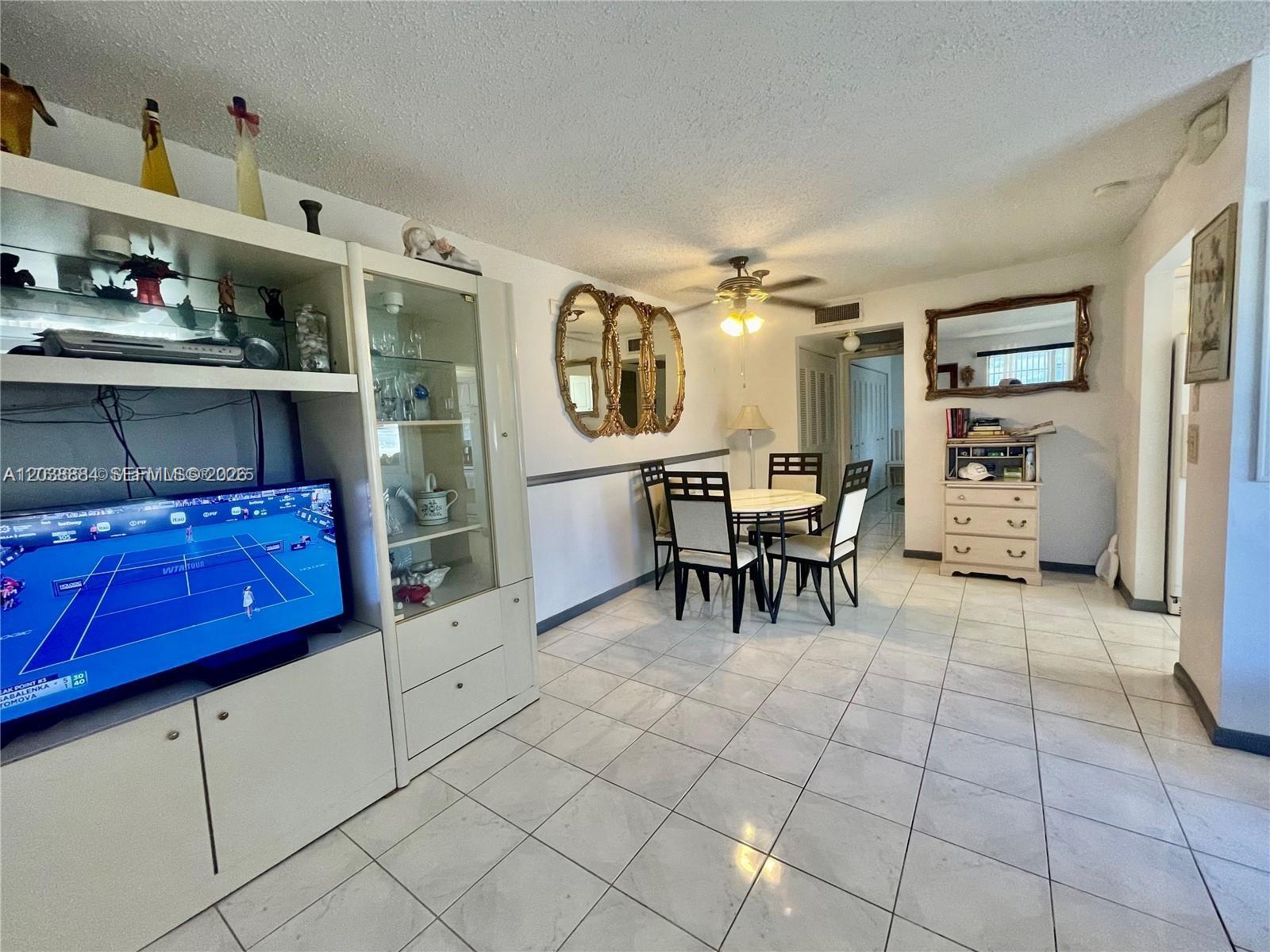 A dining area and living space feature white tile floors, a ceiling fan, and cabinetry — 337 Durham J # 337, Deerfield Beach FL 33442, DEERFIELD BEACH, FL
