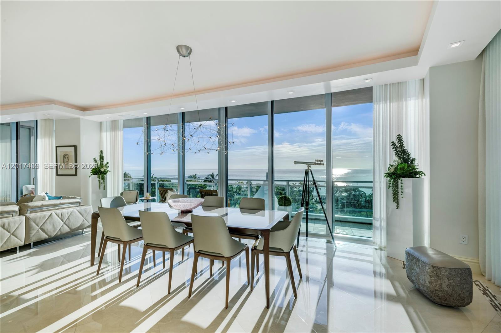 A dining room with a glass table, modern chairs, and floor-to-ceiling windows overlooking the ocean — 10295 Collins Ave # 301, Bal Harbour FL 33154, BAL HARBOUR, FL