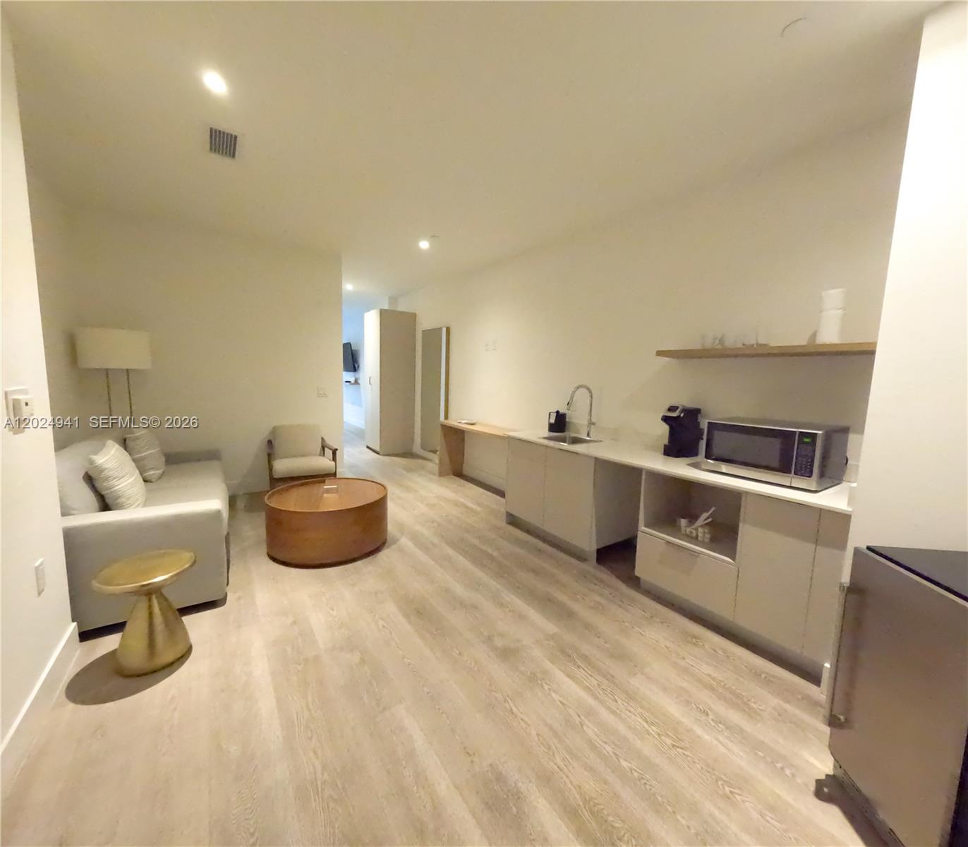 This studio apartment features a kitchenette, a seating area, and light-colored wood-look flooring — 229 SW 9th St # 508, Miami FL 33130, MIAMI, FL