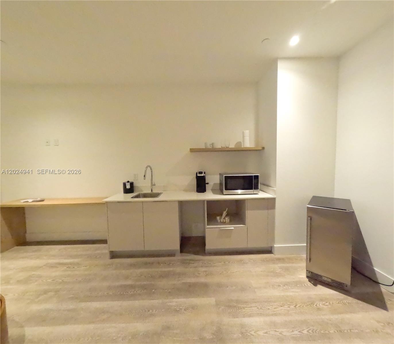 A kitchenette features light-colored cabinetry, a sink, a microwave, and a small refrigerator — 229 SW 9th St # 508, Miami FL 33130, MIAMI, FL