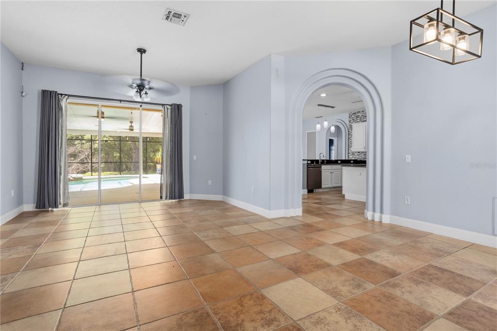 This digital rendering shows a living room with a sofa, armchairs, and a pool view — 334 GRAND RESERVE DRIVE, DAVENPORT, FL