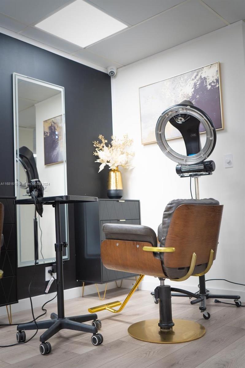 A salon station features a styling chair, a ring light, a mirror, and a black dresser — FORT LAUDERDALE, FL