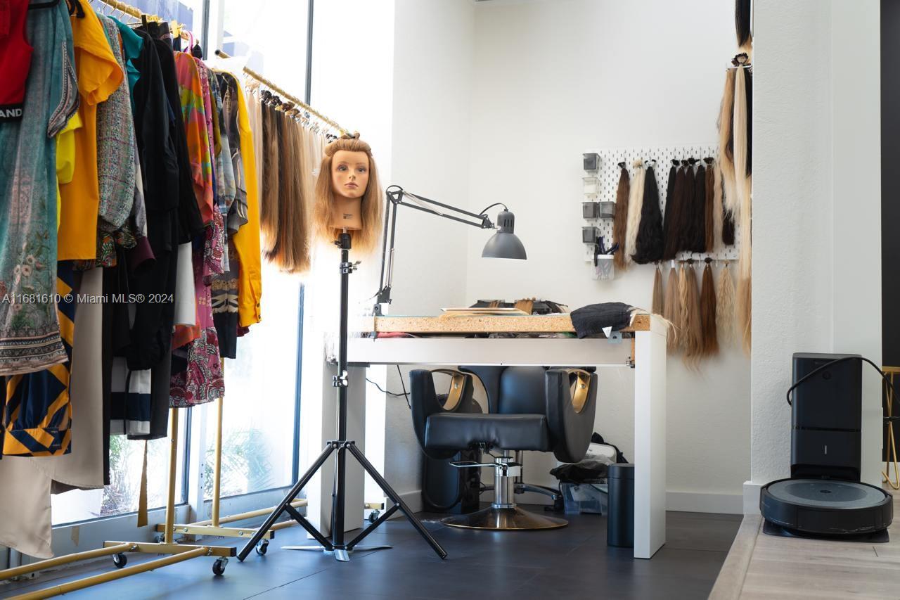 A hair extension workstation features a mannequin head, styling chair, and wall-mounted hair samples — FORT LAUDERDALE, FL