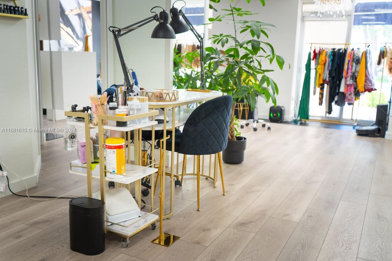 A nail technician station with a rolling cart and black chair sits in a salon — FORT LAUDERDALE, FL