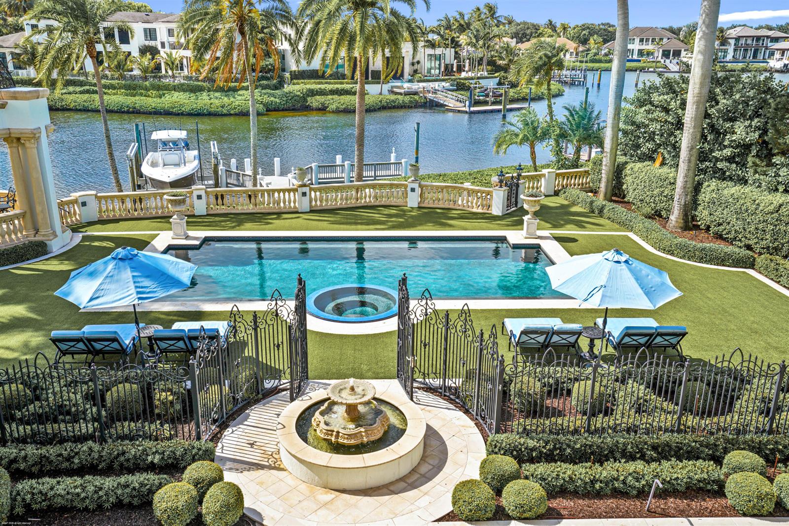 A backyard features a swimming pool, a hot tub, a fountain, and a waterfront dock — 370 Eagle Drive, Jupiter FL 33477, JUPITER, FL