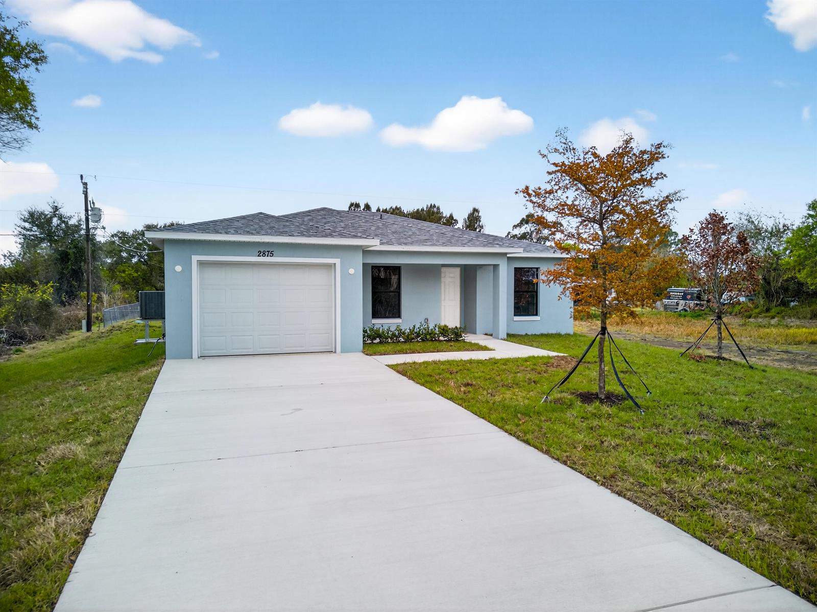 A light blue single-story house with a garage and a concrete driveway — 2875 NW 32nd Avenue, Okeechobee FL 34972, OKEECHOBEE, FL