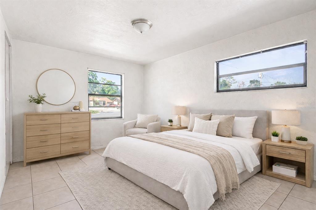 A bedroom with white walls, tile flooring, a bed, a dresser, and two windows — 34 NW 21ST PLACE, OCALA, FL