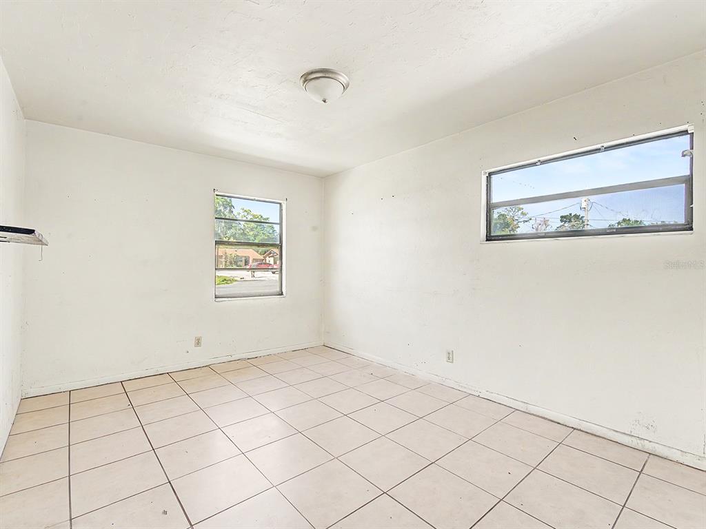 An empty bedroom features white walls, a tiled floor, and two windows — 34 NW 21ST PLACE, OCALA, FL