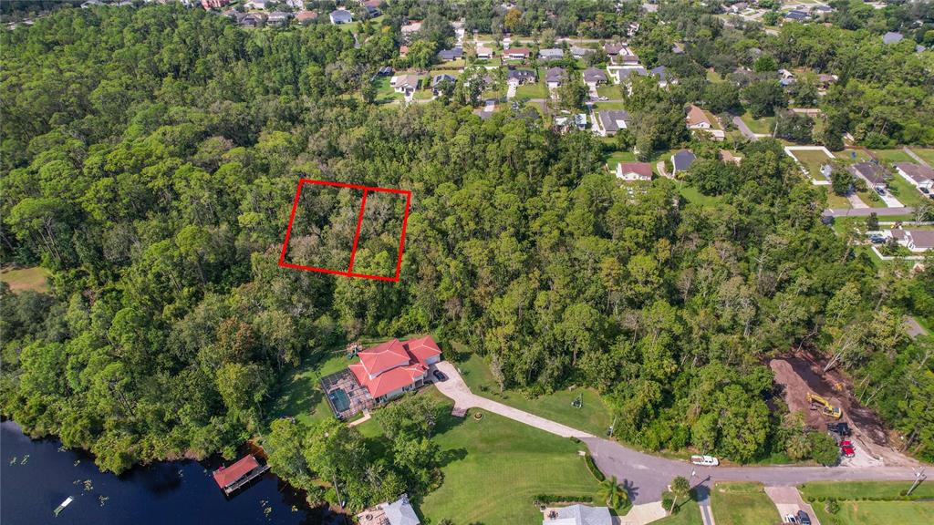 An aerial view shows a wooded lot with two red-outlined parcels near a waterfront house — W 5TH STREET, CHULUOTA, FL