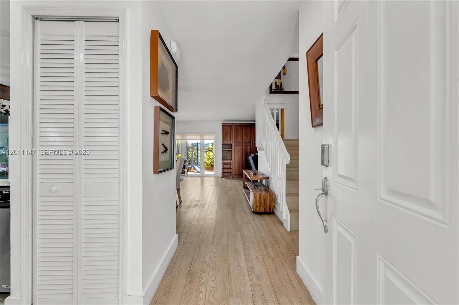 A view from an entryway looking down a hallway toward a living area with stairs — 16221 SW 72nd Ter, Miami FL 33193, MIAMI, FL