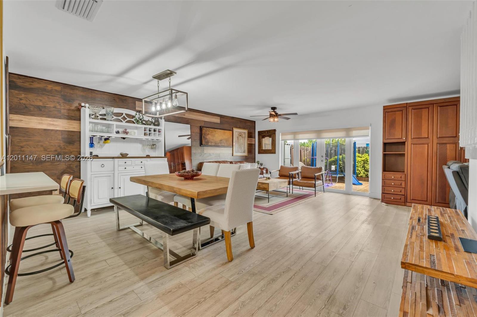 A dining and living area features wood-paneled walls, light flooring, and a large built-in hutch — 16221 SW 72nd Ter, Miami FL 33193, MIAMI, FL