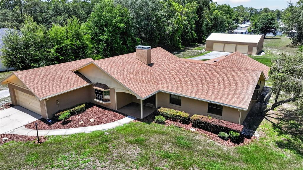 An aerial view of a single-story house with a brown shingled roof and detached garage — 815 LAKE NED ROAD, WINTER HAVEN, FL