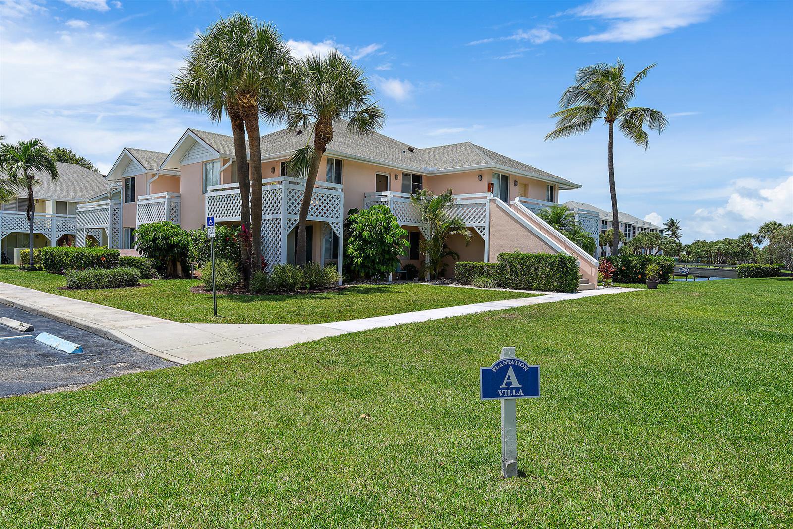 A two-story peach-colored villa building sits on a grassy lawn with palm trees — 353 S Us Hwy 1 # A8, Jupiter FL 33477, JUPITER, FL
