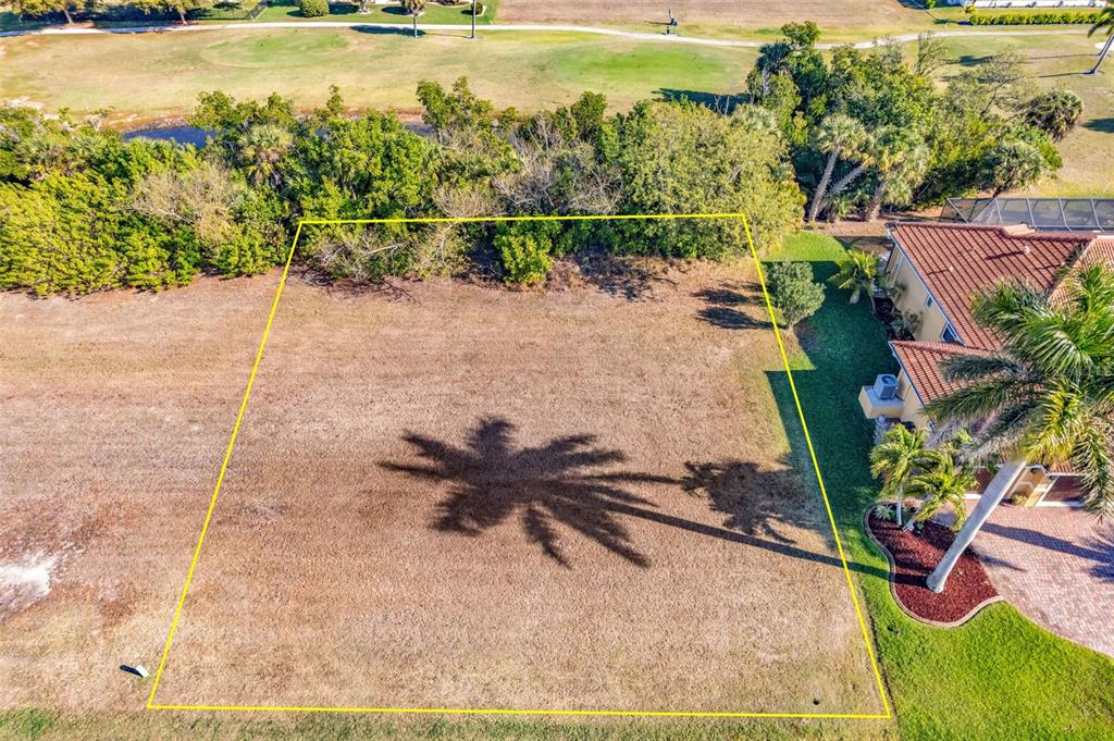 An aerial view shows a vacant rectangular lot outlined in yellow next to a house — 2316 PADRE ISLAND DRIVE, PUNTA GORDA, FL