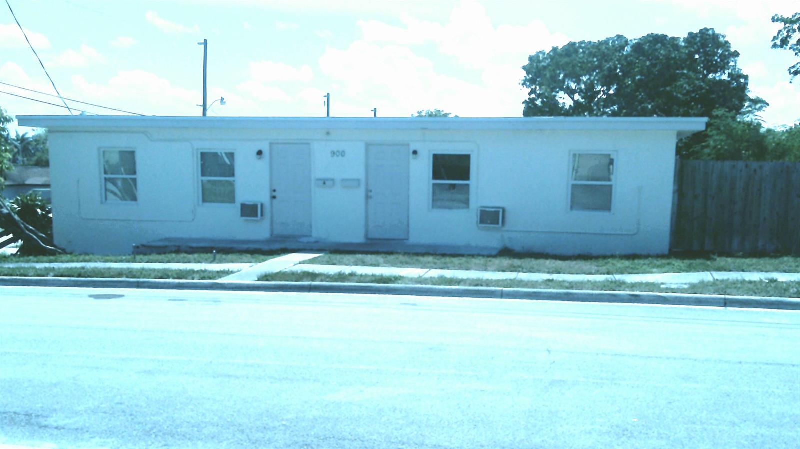 A single-story white duplex building with two front doors and window air conditioning units — 900 W 9th Street, Riviera Beach FL 33404, RIVIERA BEACH, FL