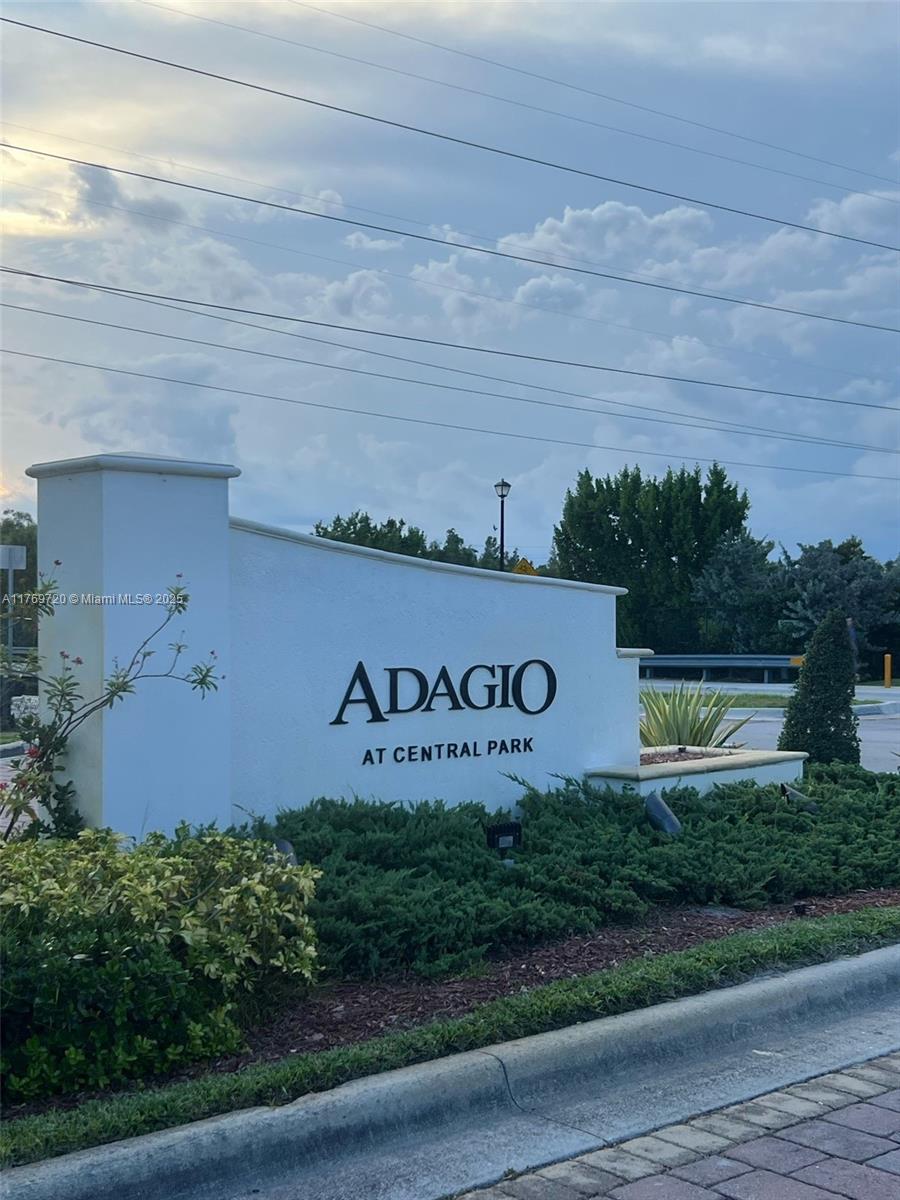 A white monument sign for Adagio at Central Park stands near a landscaped roadside — 10630 NW 88th St # 103, Doral FL 33178, DORAL, FL