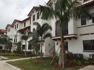 A multi-story white apartment building with a tile roof and palm trees in the foreground — 10630 NW 88th St # 103, Doral FL 33178, DORAL, FL