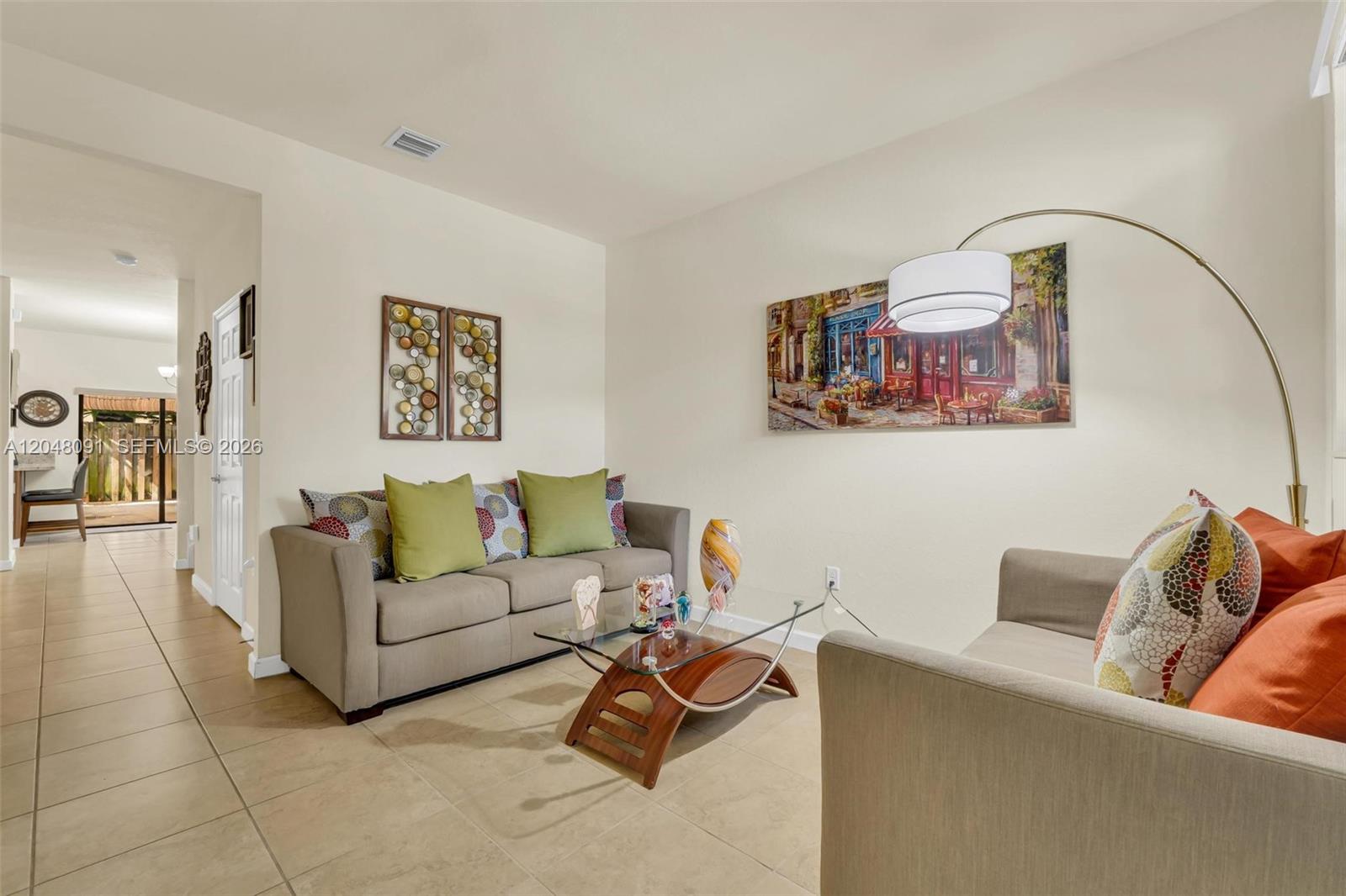 A living room features two beige sofas, a glass coffee table, and tile flooring — 3368 SE 1st St, Homestead FL 33033, HOMESTEAD, FL