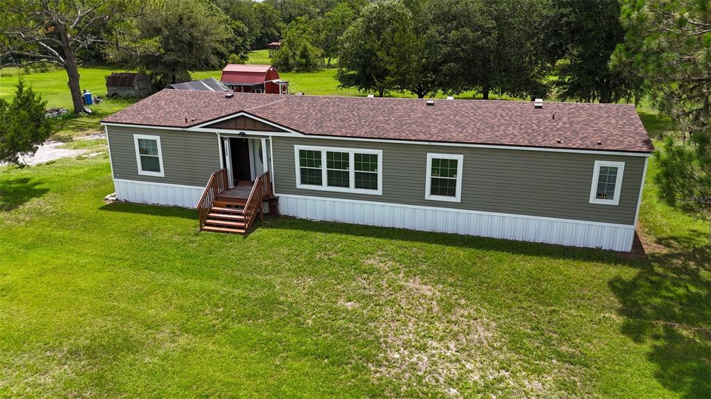 An aerial view of a single-story manufactured home with olive siding and a brown roof — 1322 FOREST PARK STREET, BUNNELL, FL