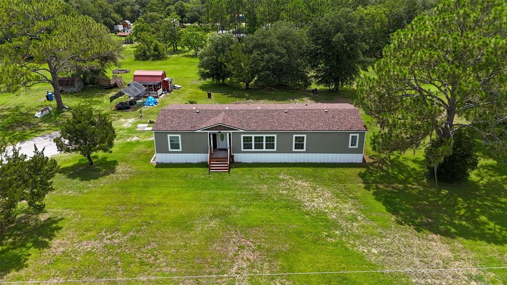 An aerial view shows a single-story manufactured home with a brown roof on a grassy lot — 1322 FOREST PARK STREET, BUNNELL, FL