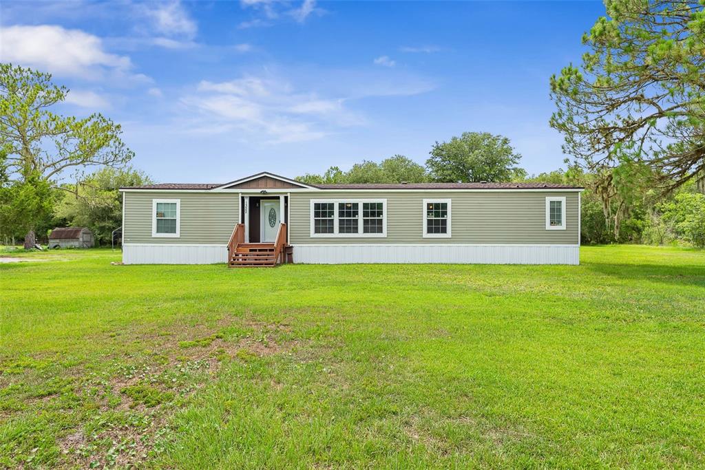 An aerial view shows a single-story house situated on a large, grassy, rectangular lot — 1322 FOREST PARK STREET, BUNNELL, FL
