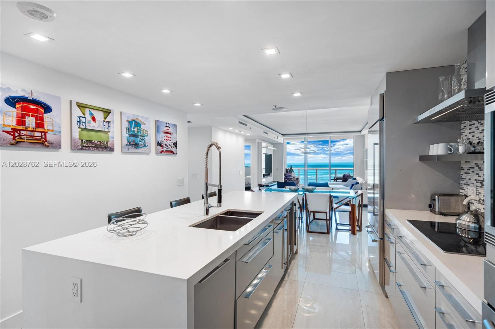 A modern kitchen features a white island with a sink, stainless appliances, and ocean views — 3801 Collins Ave # 703, Miami Beach FL 33140, MIAMI BEACH, FL