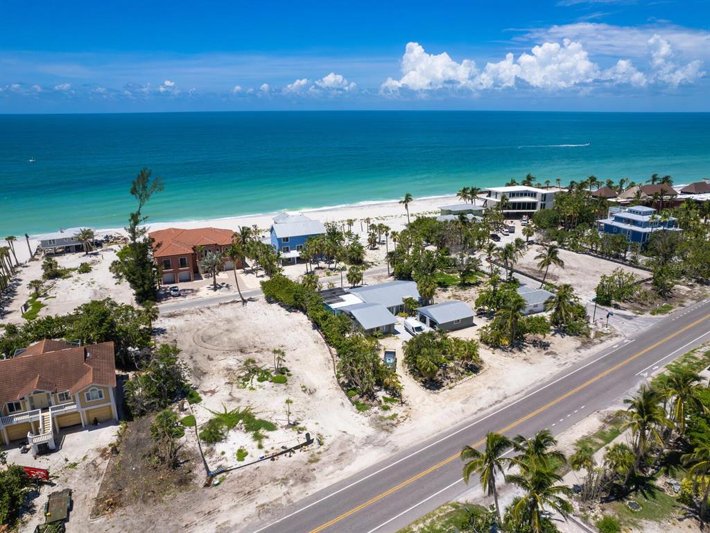 An aerial view of a coastal property with a house, vacant lots, and beach access — 6549 GULF OF MEXICO DRIVE, LONGBOAT KEY, FL
