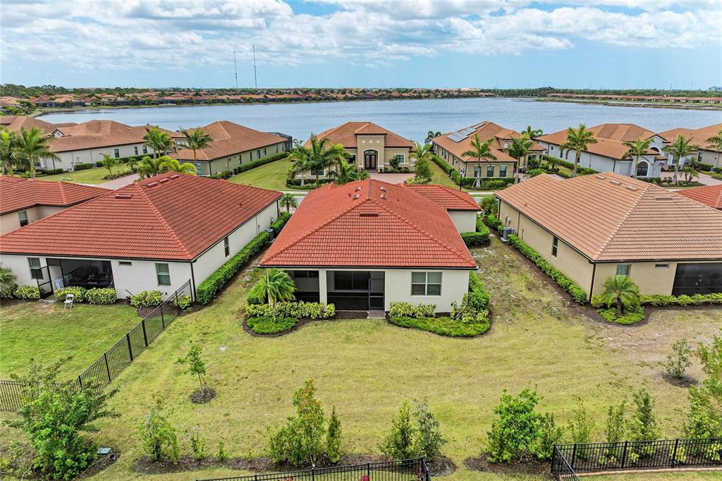 An aerial view shows the rear exterior of a suburban house with a screened patio — 564 MARAVIYA BOULEVARD, NOKOMIS, FL