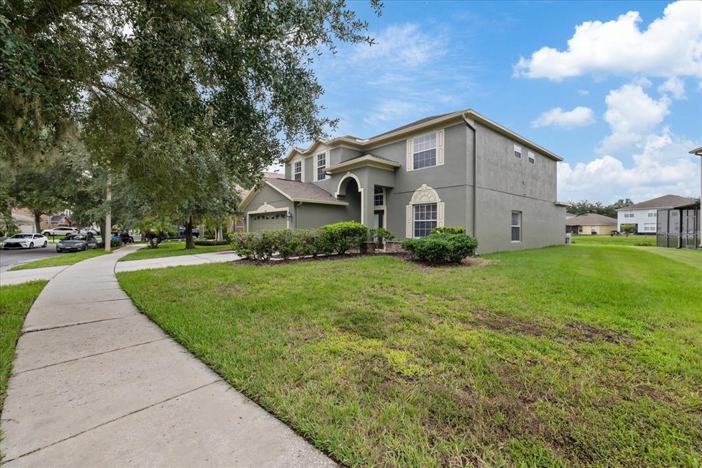 A two-story gray house with a side-entry garage and a sidewalk in the foreground — 10616 LIBERTY BELL DRIVE, TAMPA, FL