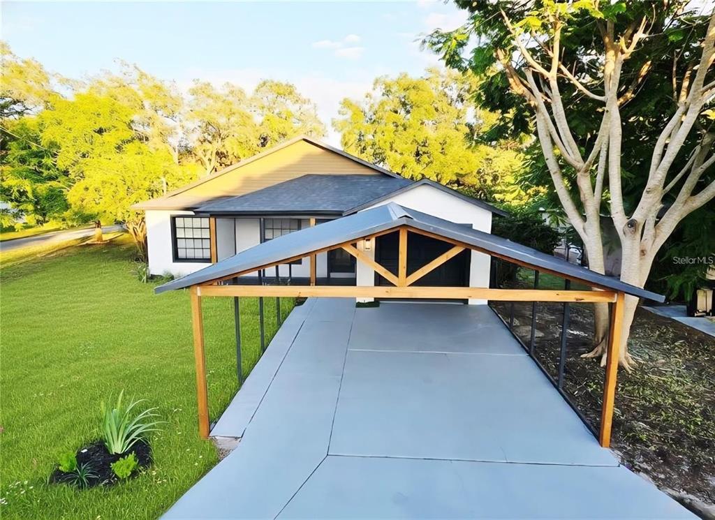 A house exterior features a gray metal carport covering a concrete driveway in the front yard — 531 1ST AVENUE, ALTAMONTE SPRINGS, FL