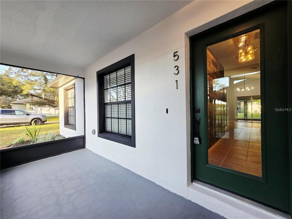 A covered porch features a dark-framed glass front door and a window with black trim — 531 1ST AVENUE, ALTAMONTE SPRINGS, FL