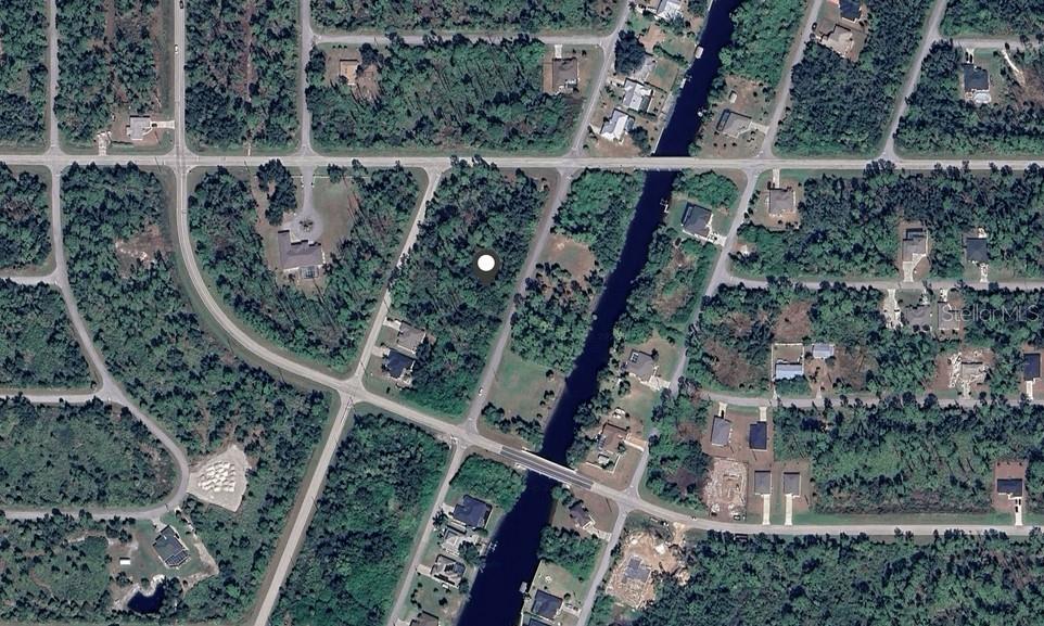 This aerial map view shows a vacant, wooded residential lot situated near a canal — 13528 IRWIN DRIVE, PORT CHARLOTTE, FL
