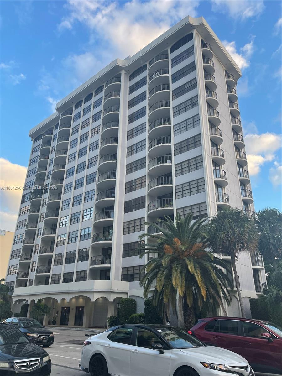A multi-story white residential apartment building features curved balconies and a palm tree in front — 66 Valencia Ave, Coral Gables FL 33134, CORAL GABLES, FL